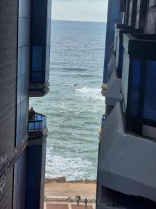 una vista del océano desde dos edificios en Your Home Apartment, en Alejandría