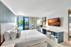 パームビーチにあるTideline Palm Beach Ocean Resort and Spaのベッドとデスクが備わるホテルルームです。