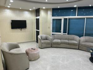een woonkamer met banken en een flatscreen-tv bij شالية 3 غرف على شرم ابحر - جدة - السعودية in Obhor