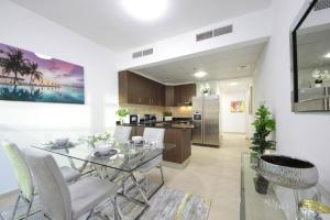 a dining room and kitchen with a glass table and chairs at Sunny Seaside 2 Bedroom Apartment, Dubai Marina in Dubai