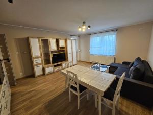ein Wohnzimmer mit einem Tisch und einem Sofa in der Unterkunft Apartament Nowa Piakowa 2 in Wągrowiec