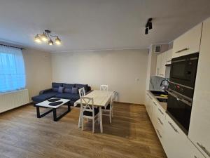 eine Küche und ein Wohnzimmer mit einem Tisch und einem Sofa in der Unterkunft Apartament Nowa Piakowa 2 in Wągrowiec