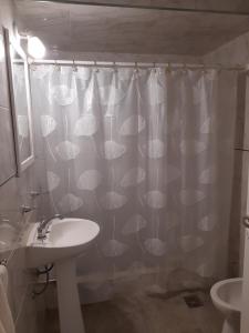 a bathroom with a shower curtain with a sink at Departamento Interno Divino! in Balcarce