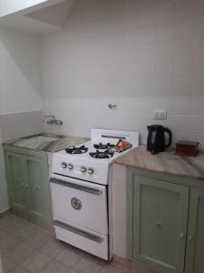 a kitchen with a white stove and a sink at Departamento Interno Divino! in Balcarce