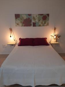 a bedroom with a large white bed with two lamps at Departamento Interno Divino! in Balcarce