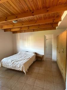1 dormitorio con cama y techo de madera en Departamento Céntrico Estilo Centroeuropeo - FEPANGUS en Villa General Belgrano