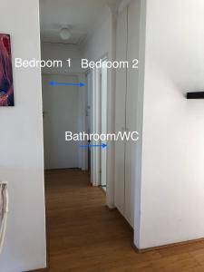 开普敦Bright and tranquil home in beautiful Hout Bay的一条带白色墙壁和木地板的走廊和一扇门