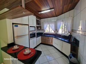 una cucina con elettrodomestici bianchi e soffitti in legno di Casa A Cammino di Venezia Hospedagem pra toda familia a Nova Veneza
