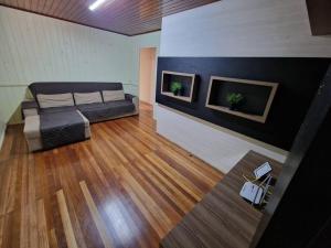 ein Wohnzimmer mit einem Sofa und zwei Pflanzen in der Unterkunft Inteira casa A Cammino di Venezia in Nova Veneza