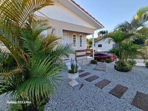 a backyard with palm trees and a house at Inteira casa A Cammino di Venezia in Nova Veneza