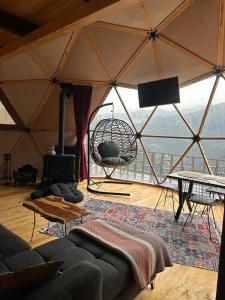 a living room with a tent with a couch and a swing at LİMKHONA DOME - CHALET in Çamlıhemşin