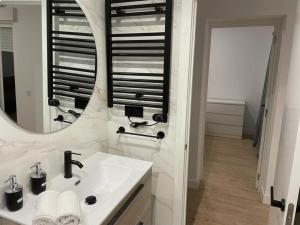 Baño blanco con lavabo y espejo en U2 Apartamento a estrenar, cerca de Metro en Madrid