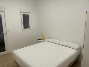 Habitación blanca con cama y ventana en U2 Apartamento a estrenar, cerca de Metro en Madrid