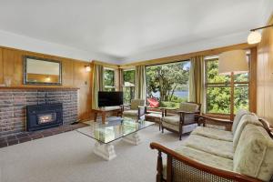 a living room with a couch and a fireplace at Okareka Lakefront in Rotorua
