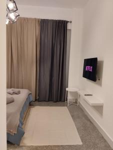 1 dormitorio con 1 cama y TV en la pared en PANSEA 03 IsimeriaHomz en Tesalónica