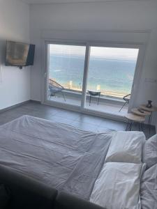a bedroom with a bed and a view of the ocean at Seafront Apartment in Skala Mistegnon