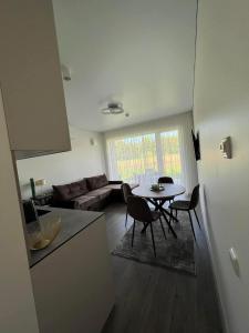 a living room with a table and a couch at Beautiful MagicSea apartment with pool area grill zone parking space 800m to sea pet friendly in Palanga