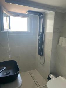 a bathroom with a shower with a black toilet and a window at Seafront Apartment in Skala Mistegnon +32 photos