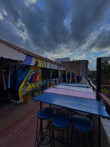 a table and stools on a roof with a mural at Central Paz Hostel in Villa Carlos Paz