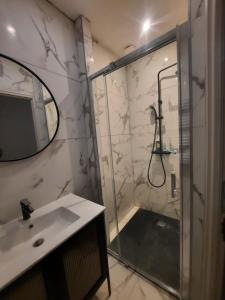 a bathroom with a shower and a sink and a mirror at Le refuge du bonheur in Trévoux