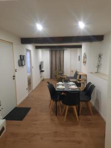 a dining room and living room with a table and chairs at Le refuge du bonheur in Trévoux
