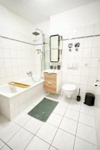 La salle de bains blanche est pourvue d'un lavabo et de toilettes. dans l'établissement Design Apartment - Boxspringbett - Waschmaschine - 55 Zoll Smart-TV - Netflix inklusive - Arbeitsplatz, à Magdebourg