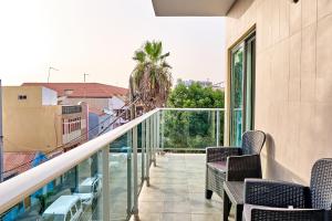 uma varanda com cadeiras e vista para um edifício em Lc Apartments - Sunday em Santa Maria