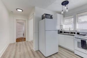 a white kitchen with a refrigerator and a stove at Heart of Cooper Young in Memphis