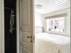 um quarto branco com uma cama e uma janela em Holiday home SKÖVDE em Skövde