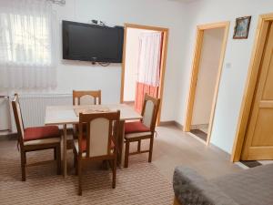 a dining room with a table and chairs and a television at Apartment Tina Gračac in Gračac