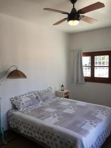 1 dormitorio con 1 cama y ventilador de techo en El depto de Bowie en Santa Rosa de Calamuchita