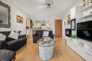 uma sala de estar com um sofá e uma televisão em Boutique Quayside Penthouse em Gateshead