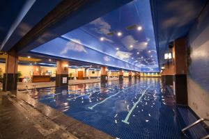 een zwembad met blauwe tegels in een gebouw bij Huachen International Hotel in Chongqing