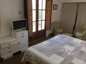 1 dormitorio con cama y vestidor con TV en El depto de Bowie en Santa Rosa de Calamuchita