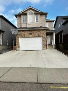 a house with a white garage door in a driveway at Comfortable room O in Kitchener