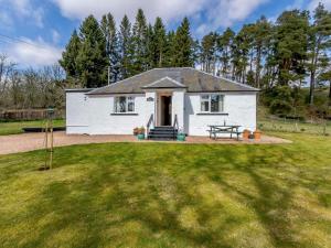 una casa blanca con una mesa de picnic en un patio en 3 bed in Kirriemuir 82244, en Kirriemuir