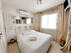 1 dormitorio con cama blanca y ventana en Villa spa hamman sauna en Juan-les-Pins