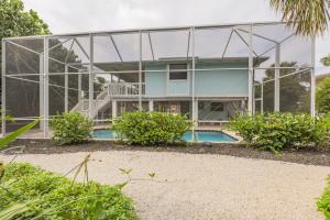 una casa de cristal con piscina frente a ella en Down Time, en Sanibel