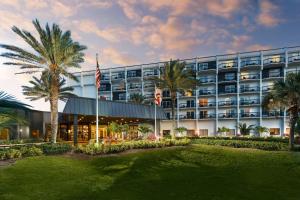 een hotel met palmbomen ervoor bij Hilton Garden Inn Cocoa Beach-Oceanfront, FL in Cocoa Beach