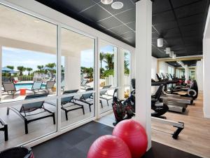 une salle de sport intérieure avec tapis de course et matériel d'exercice dans l'établissement Hilton Garden Inn Cocoa Beach-Oceanfront, FL, à Cocoa Beach