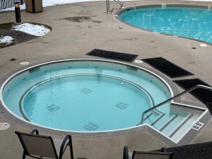 a large swimming pool with chairs around it at Canmore Mountain Retreat - Heated Pool & Hot-tub in Canmore