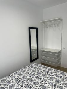 a bedroom with a bed with a mirror and shelves at Luminoso dúplex con parking in Terrassa