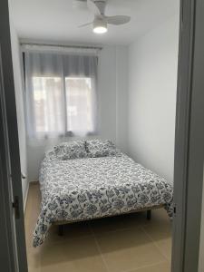 a bed in a bedroom with a ceiling fan at Luminoso dúplex con parking in Terrassa