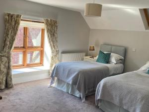 a bedroom with two beds and a window at Mill Pond Cottage in Taunton