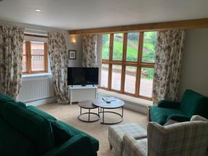 a living room with a couch and a tv at Mill Pond Cottage in Taunton