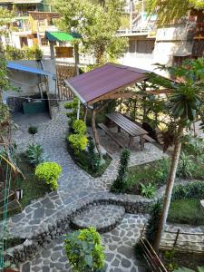 a picnic table and a bench in a garden at Casa Madera in San Marcos La Laguna