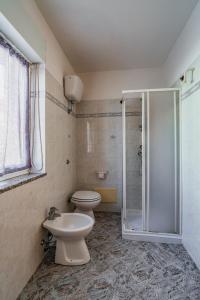 a bathroom with a toilet and a glass shower at Bosa Mare & Relax in Bosa Marina +12 photos