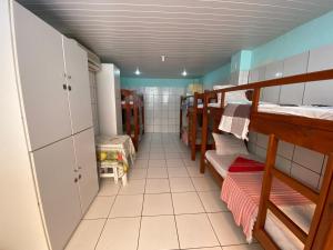 a room with two bunk beds and a bathroom at A Casa dos Mestres in Salvador