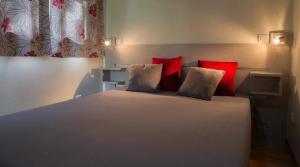 - une chambre avec un grand lit blanc et des oreillers rouges dans l'établissement Chalet l'Arcange 2 a 6 personnes au calme bord riviere Lison Franche Comte, à Nans-sous-Sainte-Anne