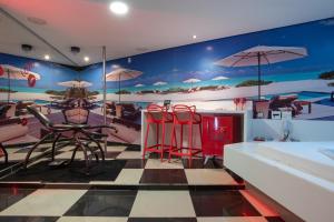 a room with a bed and chairs and a table at Motel Fantasy 1 in Belo Horizonte